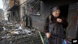 Svitlana Magdenko, 79, stands in front of her damaged house after a Russian rocket attack at a residential neighborhood in Kyiv, Ukraine, Dec. 13, 2023. 