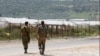 FILE - Israeli soldiers patrol along the road by the security fence near Ibthan in central Israel separating it from the occupied West Bank, April 13, 2022. 
