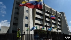 FILE - A member of the National Guard walks past the Supreme Justice Tribunal building in Caracas, Jan. 29, 2019.