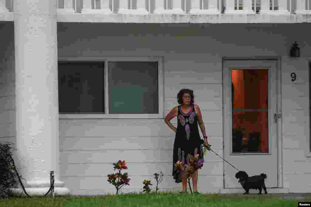 Una mujer se encuentra afuera de su residencia durante la lluvia y el viento del huracán Idalia en Clearwater, Florida.