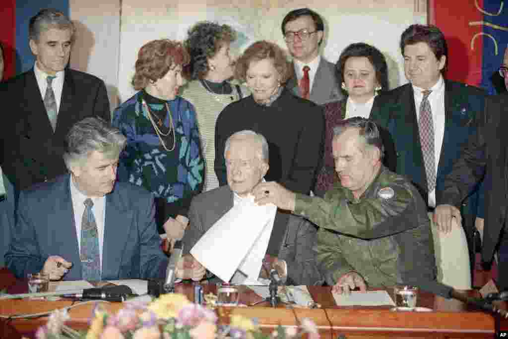 After seven hours of talks at the Bosnian Serb headquarters in Pale, Bosnia, former U.S. President Jimmy Carter, center, Bosnia Serb leader Radovan Karadzic, left, and Bosnian Serb army Commander Ratko Mladic, right, signed a declaration proposing a four-month ceasefire in the Bosnian war, Dec. 19, 1994. 