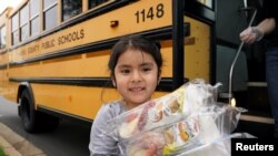 Una niña recibe almuerzo gratuito en Falls Church, Virginia, el 20 de marzo del 2020. 