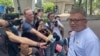 Hong Kong Journalists Association's Chairman Ronson Chan, right, speaks to reporters outside a court building in Hong Kong, Sept. 25, 2023. 
