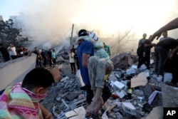 A Palestinian man evacuates a wounded girl out of the destruction following Israeli airstrikes on Gaza City, Oct. 25, 2023.
