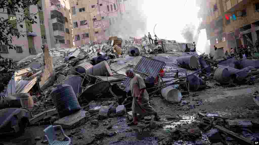 Varios palestinos inspeccionan los escombros de un edificio, luego que fuera alcanzado por un ataque aéreo israelí en la ciudad de Gaza. Se desconoce el número de víctimas.