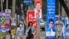 Orang-orang berjalan melewati poster kampanye pemilu di Bangkok, sementara Thailand akan mengadakan pemilihan umum pada 14 Mei mendatang. 