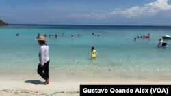 Vladimir Ríos, un prestador de servicios de trampolines y botes inflables, camina por la playa del cayo Playuela en el estado Falcón, Venezuela.