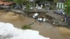 Esta imagen proporcionada por el gobierno de Sao Paulo muestra vehículos de caídos de una zona desmoronada junto a la playa en Sao Sebastiao, al este de Sao Paulo, Brasil, el domingo 19 de febrero de 2023, tras una fuerte tormenta en la zona