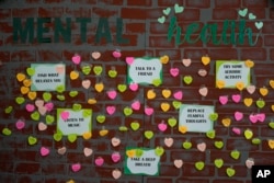 Notes from students expressing support and sharing coping strategies paper a wall.(AP Photo/Rebecca Blackwell)