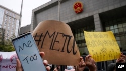 资料照 - 2020年12月2日，一位名叫周晓轩（音译）的中国女子控告被性骚扰案件在北京一法院开庭审理。照片显示支持周晓轩的人群在法庭外举牌声援。