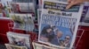 A woman buys a copy of the British Mail on Sunday newspaper at a news stand in London, July 14, 2024, showing the reaction to events at former U.S. President Donald Trump's campaign rally in Butler, Pennsylvania. 