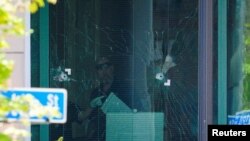 Los investigadores inspeccionan los agujeros de bala en la escena del tiroteo masivo en el Old National Bank, ocurrido en el centro de Louisville, Kentucky, EEUU, el 10 de abril de 2023.