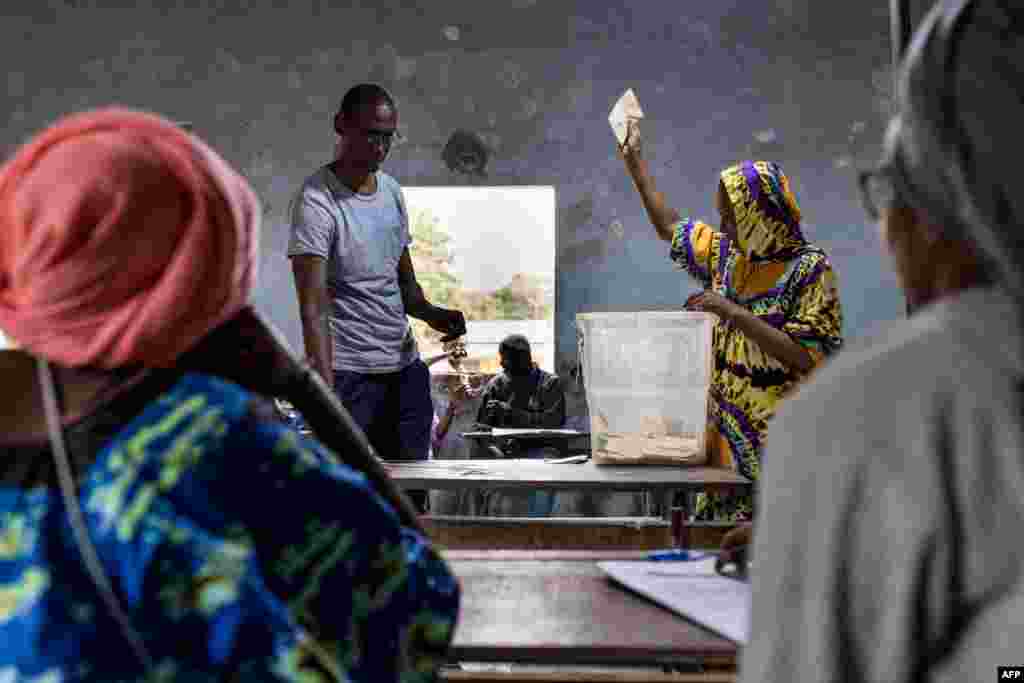 Um funcionário de uma assembleia de voto segura um boletim de voto durante o processo de contagem em Ziguinchor, a 24 de março de 2024, durante as eleições presidenciais senegalesas.