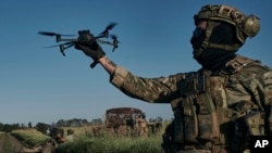 A Ukrainian soldier of the 28th brigade launches a drone at the frontline close to Bakhmut, Ukraine, Aug. 20, 2023.