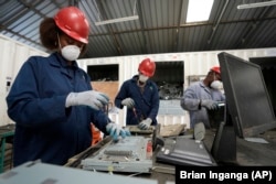 Employees dismantle laptop waste at WEEE center recycling plant, a collection point where people can deposit old electric equipment in Nairobi, Kenya Wednesday, March. 20, 2024. (AP Photo/Brian Inganga)
