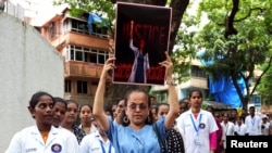 Doctors and residents hold posters and shout slogans during a protest in Mumbai, India, condemning the rape and murder of a trainee medic at a government-run hospital in Kolkata, Aug. 18, 2024. 