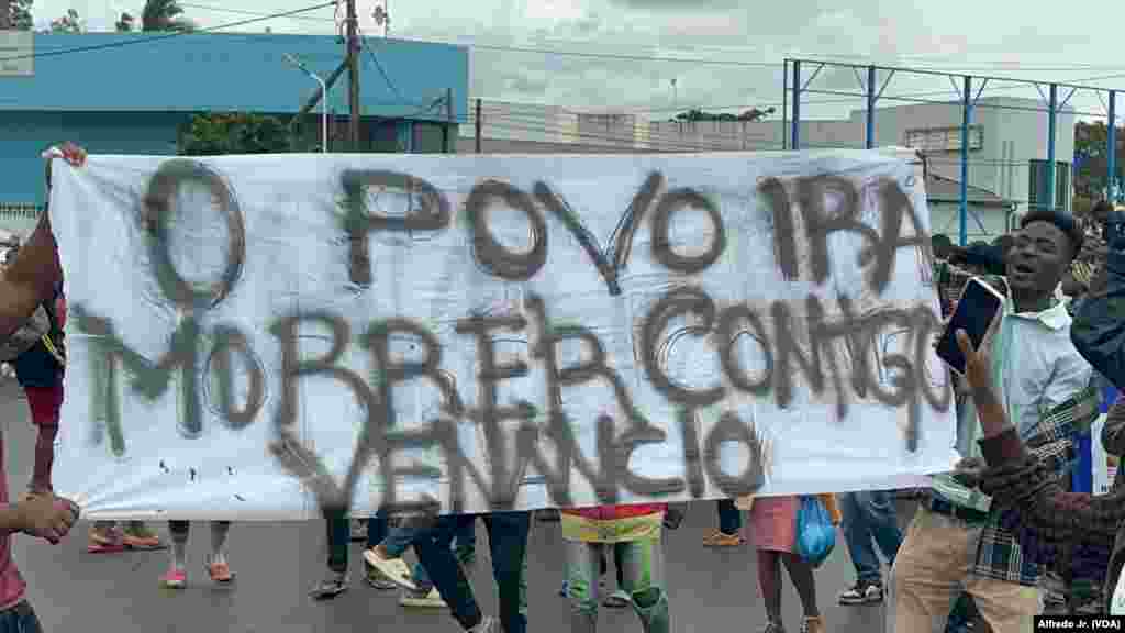 Manifestantes seguram um cartaz demonstrando o seu apoio a Venâncio Mondlane, que concorreu à liderança de Maputo