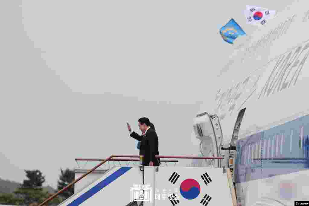 윤석열 한국 대통령과 부인 김건희 여사가 24일 성남 서울공항에서 5박 7일 미국 국빈 방문을 위해 공군 1호기에 오르며 인사하고 있다. (한국 대통령실 제공)