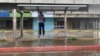 Un hombre se encarama sobre una banca en una parada del transporte en Maracaibo, Zulia, durante un chubasco, el 2 de junio de 2023. Las autoridades esperan fuertes lluvias en el norte de Venezuela, especialmente en los estados Zulia y Falcón, por el paso de Bret por el Caribe.