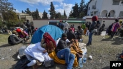 ARCHIVES - Des migrants campent devant l'ambassade de Côte d'Ivoire à Tunis le 28 février 2023.
