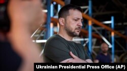 Ukraine's President Volodymyr Zelenskyy looks at burnt books in a damaged workshop of Ukraine's largest printing house ruined in Thursday's deadly Russian missile attack that killed seven civilians in Kharkiv, Ukraine, May 24, 2024.