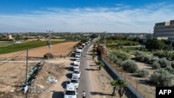 Esta vista aérea mostra camiões de ajuda humanitária que chegam do Egito depois de terem atravessado o posto fronteiriço de Rafah e chegado a uma instalação de armazenamento em Khan Yunis, no sul da Faixa de Gaza, a 21 de outubro de 2023.