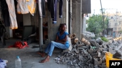 Una niña palestina desplazada se sienta en un edificio dañado utilizado como refugio temporal en el campo de refugiados de al-Bureij, en el centro de la Franja de Gaza, el 12 de junio de 2024.