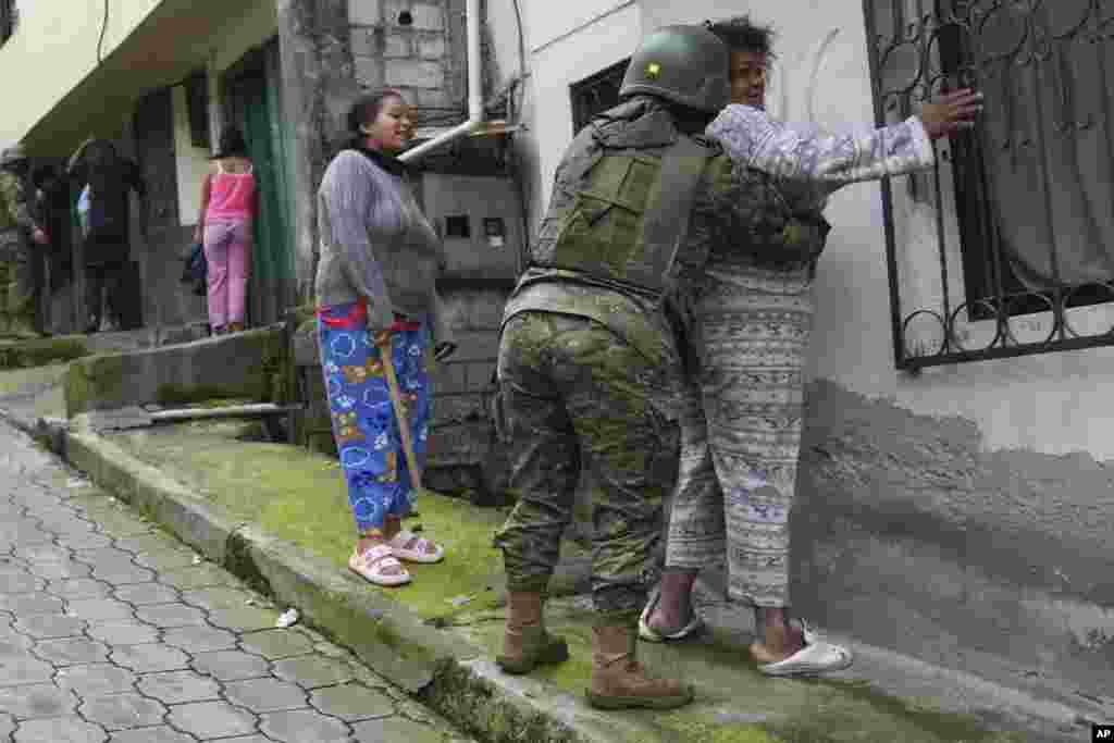 Soldados registran a mujeres mientras patrullan el lado sur de Quito, Ecuador, el 12 de enero de 2024, tras la aparente fuga de un poderoso líder de una pandilla de prisión. El presidente Daniel Noboa decretó el lunes estado de emergencia nacional, una medida que permite a las autoridades suspender los derechos de las personas y movilizar a los militares en lugares como las cárceles. (Foto AP/Dolores Ochoa). 