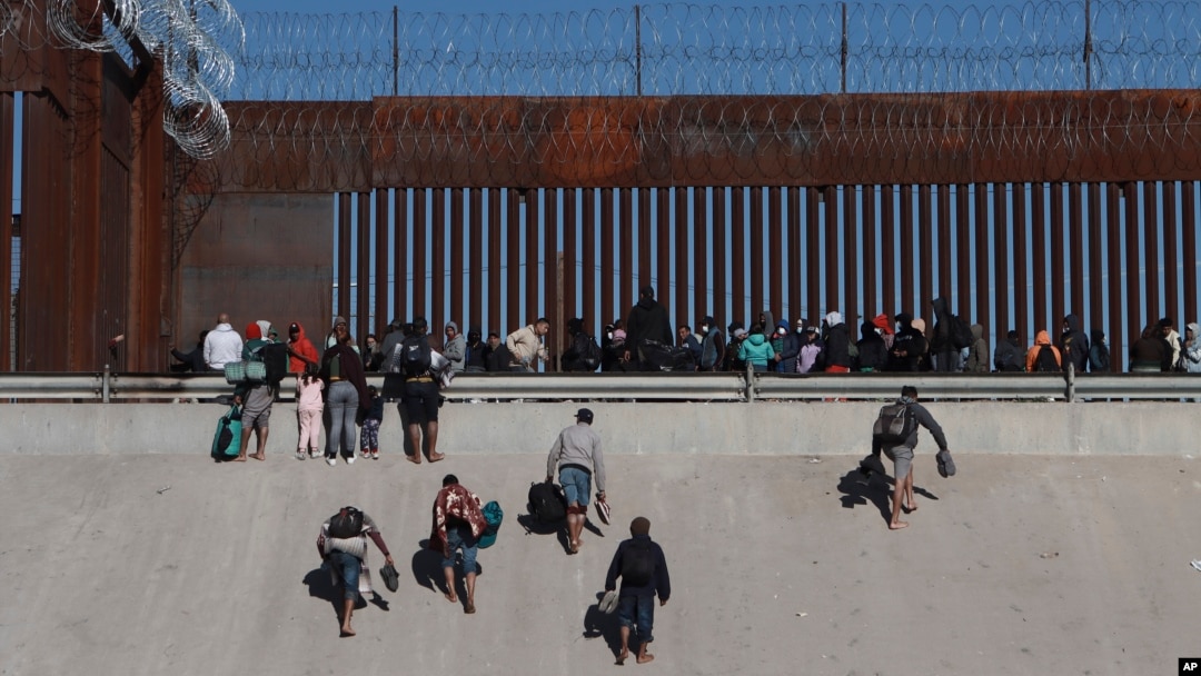 Migrantes se acercan al muro fronterizo en Ciudad Juárez, México, el 21 de diciembre de 2022, al otro lado de la frontera desde El Paso, Texas, EEUU.