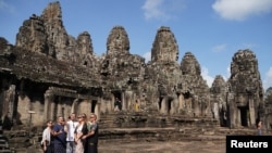 ភ្ញៀវទេសចរថតរូបជាអនុស្សាវរីយ៍នៅប្រាសាទអង្គរធំ ក្នុងខេត្តសៀមរាប កាលពីថ្ងៃទី ១៤ ខែមករា ឆ្នាំ ២០២៣។ 