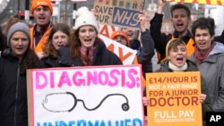 Junior doctors hold placards as they stand at a picket line outside St. Thomas' Hospital in Westminster in London, March 13, 2023. 