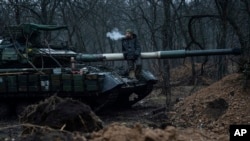 Un militar ucraniano fuma un cigarrillo sobre un tanque cerca de Bakhmut, Ucrania, el 8 de marzo de 2023.