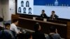 香港当局在记者会上公布被通缉的五名活动人士的照片。（2023年12月14日）