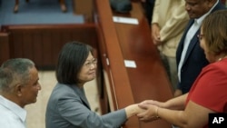 Presiden Taiwan Tsai Ing-wen (tengah) berjabat tangan dengan seorang senator di akhir kunjungannya ke Majelis Nasional di Belmopan, Belize, pada 3 April 2023. (Foto: AP/Moises Castillo)