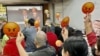 多名參與財政預算案直播會的香港基層市民，高舉”嬲嬲”(不高興)表情紙牌，對俗稱”派糖“的紓困措施大幅”減甜”表達不滿。(美國之音/湯惠芸)