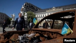 Britain's Foreign Secretary David Cameron walks past a display of destroyed Russian military vehicles in Saint Michael's Square, amid Russia's attack on Ukraine, in Kyiv, Ukraine, May 2, 2024.