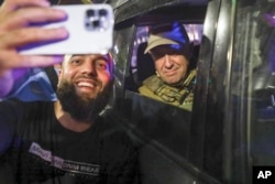 FILE - Yevgeny Prigozhin, owner of the Wagner Group military company, right, poses for a photo with a civilian after taking over the Southern Military District in Rostov-on-Don, Russia, on June 24, 2023.