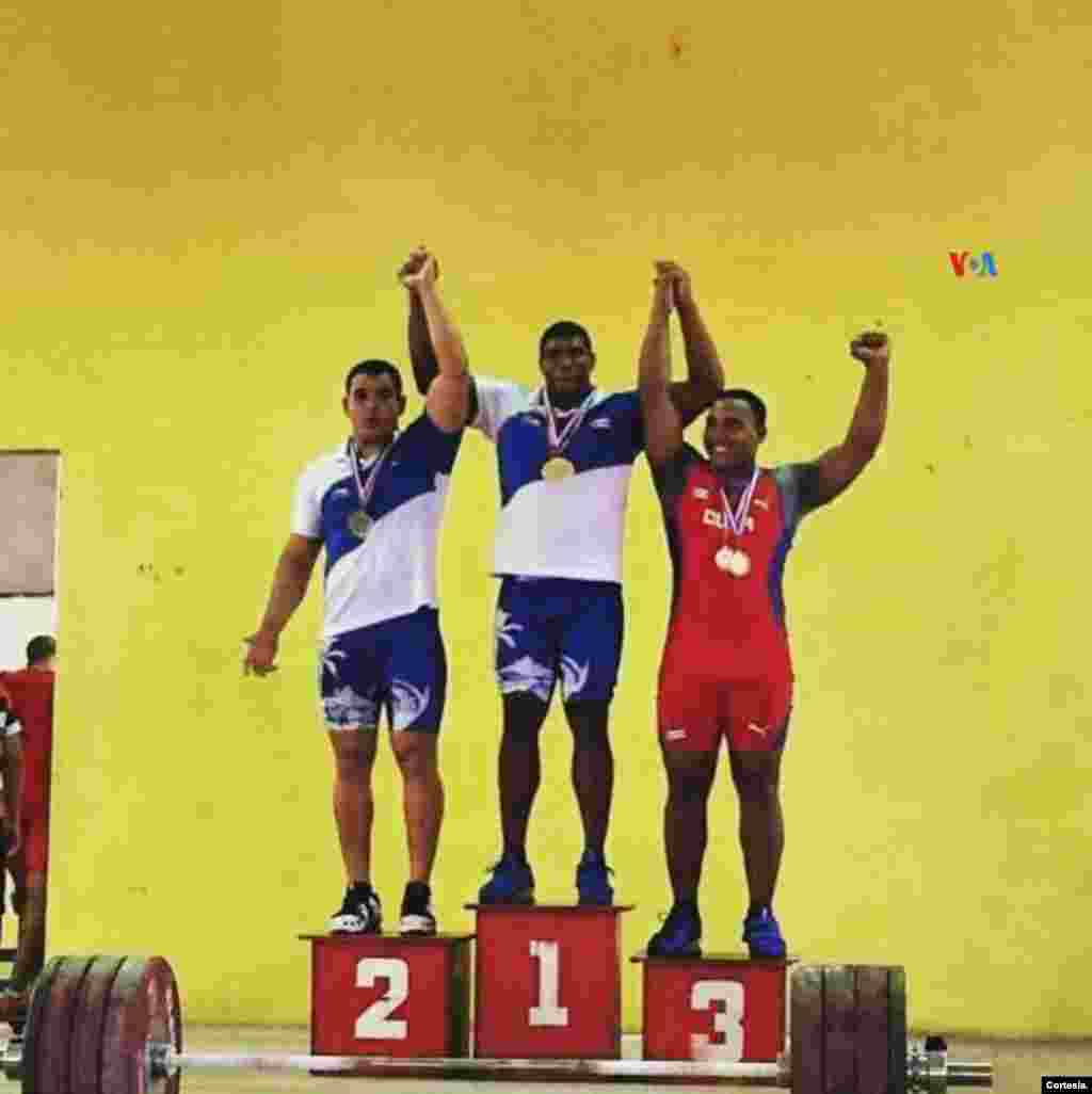 Ramiro Mora (primero a la izq.) al obtener la presea de plata en el Campeonato Nacional de Levantamiento de Pesas en Cuba, 2018, el último año en que practicó antes de irse a Londres con una compañía circense. [Foto: Cortesía]