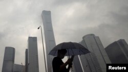 2023年7月12日，中國北京雨天，一名男子行走在中央商務區。（路透社照片）