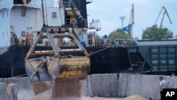 FILE - Workers load grain at a grain port in Izmail, Ukraine, April 26, 2023.