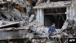 Un niño palestino juega en las ruinas de un edificio destruido por un bombardeo israelí anterior en la ciudad de Gaza el 8 de abril de 2024, en medio del conflicto en curso entre Israel y el grupo militante palestino Hamás.