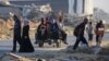Palestinos toman la carretera en Al-Maghazi mientras huyen de sus campamentos de desplazados debido a los intensos bombardeos israelíes sobre el centro de la Franja de Gaza el 5 de junio de 2024.