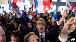 Des partisans du Rassemblement national, parti d'extrême droite français, réagissent au siège du parti lors de la soirée électorale, à Paris, le 9 juin 2024.