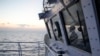 FILE - A member of the Philippine Coast Guard watches from the bridge of the BRP Malabrigo as they patrol and resupply troops at Philippine-occupied areas in the South China Sea, Apr. 19, 2023.