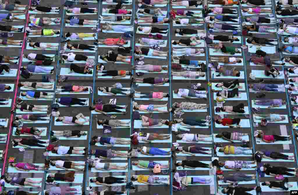 People take part in the 22nd annual "Solstice in Times Square: Mind Over Madness Yoga" in Times Square, New York City.