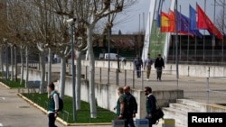 Tres guardias civiles españoles y un oficial de Europol caminan fuera de la sede de la federación de fútbol después de buscar pruebas en una investigación de corrupción, en las Rozas, España, el 20 de marzo de 2024. 
