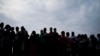 FILE - Ugandans wait to cast their votes for the presidential election in Kampala on Jan. 14, 2021.