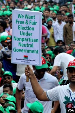 A demonstrator holds a poster at the BNP protest rally in Dhaka, Bangladesh, July 12, 2023, calling for a free and fair election. (Babul Talukdar for VOA)