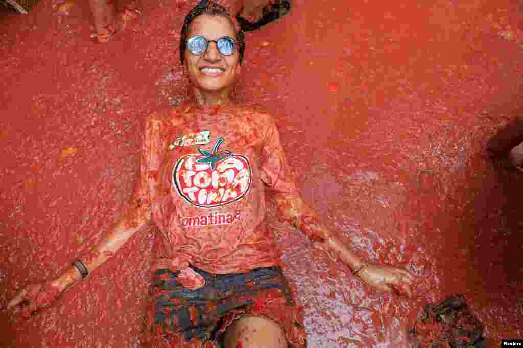 Participante deitada na polpa de tomate durante “La Tomatina” em Bunol, perto de Valência, Espanha, 28 de agosto de 2024.