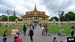 រូបឯកសារ៖ ពលរដ្ឋលំហែកាយនៅមុខព្រះរាជបរមរាជវាំង ក្នុងរាជធានីភ្នំពេញ កាលពីថ្ងៃទី ២៤ ខែកក្កដា ឆ្នាំ ២០២៣។ (Photo by TANG CHHIN Sothy / AFP)